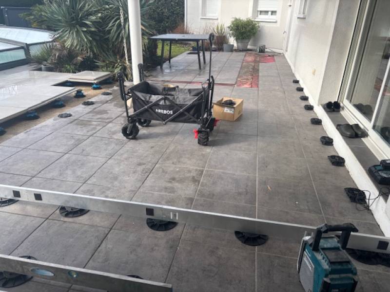 Rénovation complète de terrasse piscine en carrelage grisa avec un carrelage sur plots à Marcheprime en Gironde